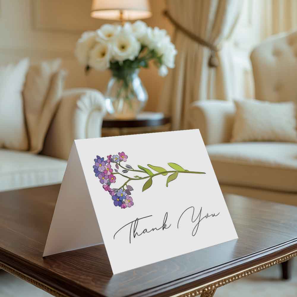 Greeting card with floral design and 'Thank You' text on a table in a living room.