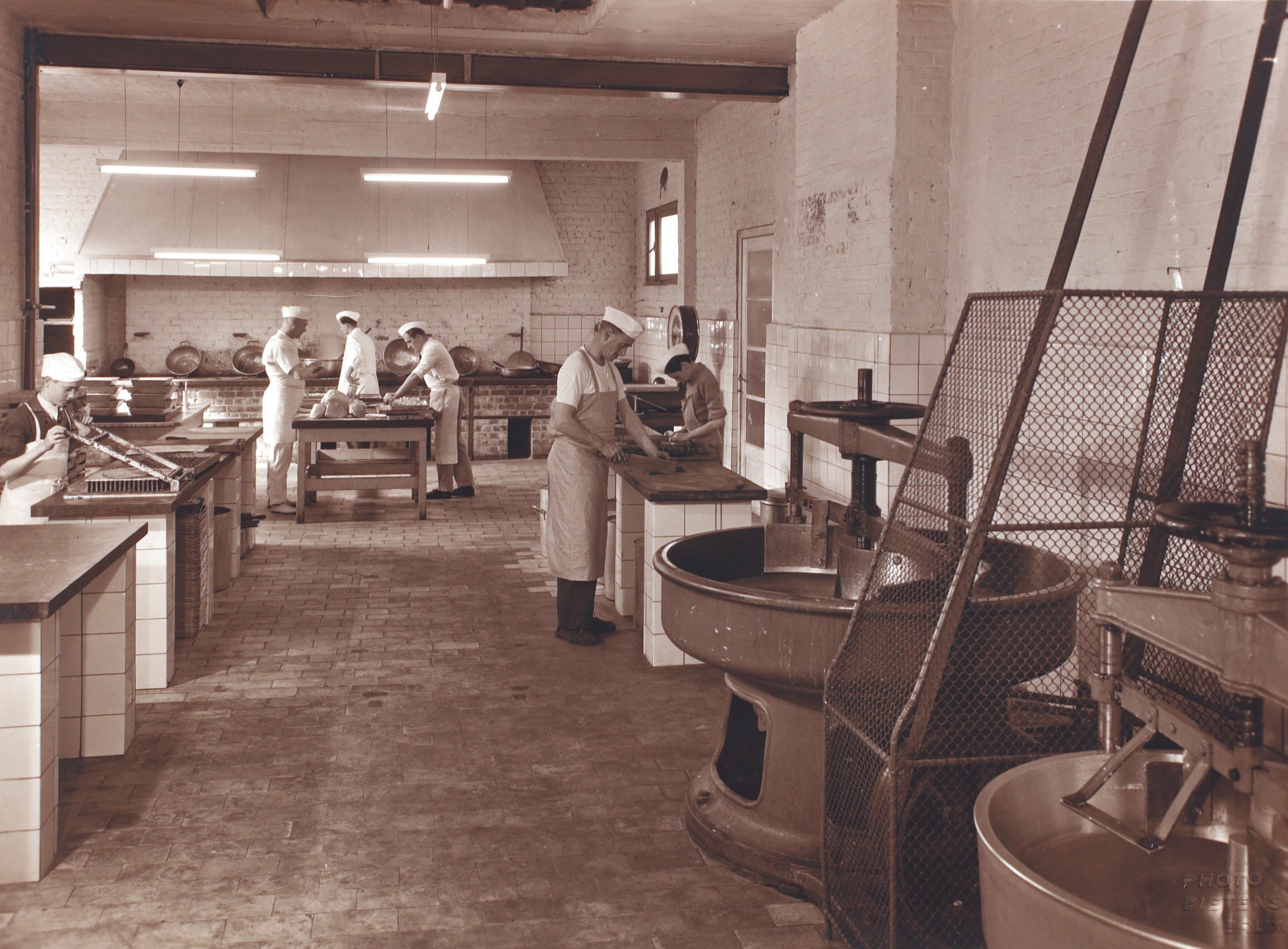 Vintage black and white photo of a kitchen with people working