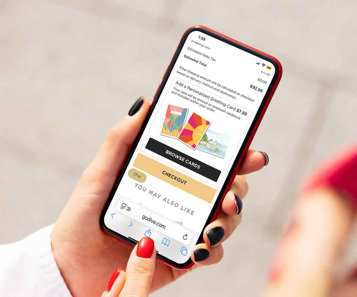 Person holding a smartphone with a shopping app open on a light gray background