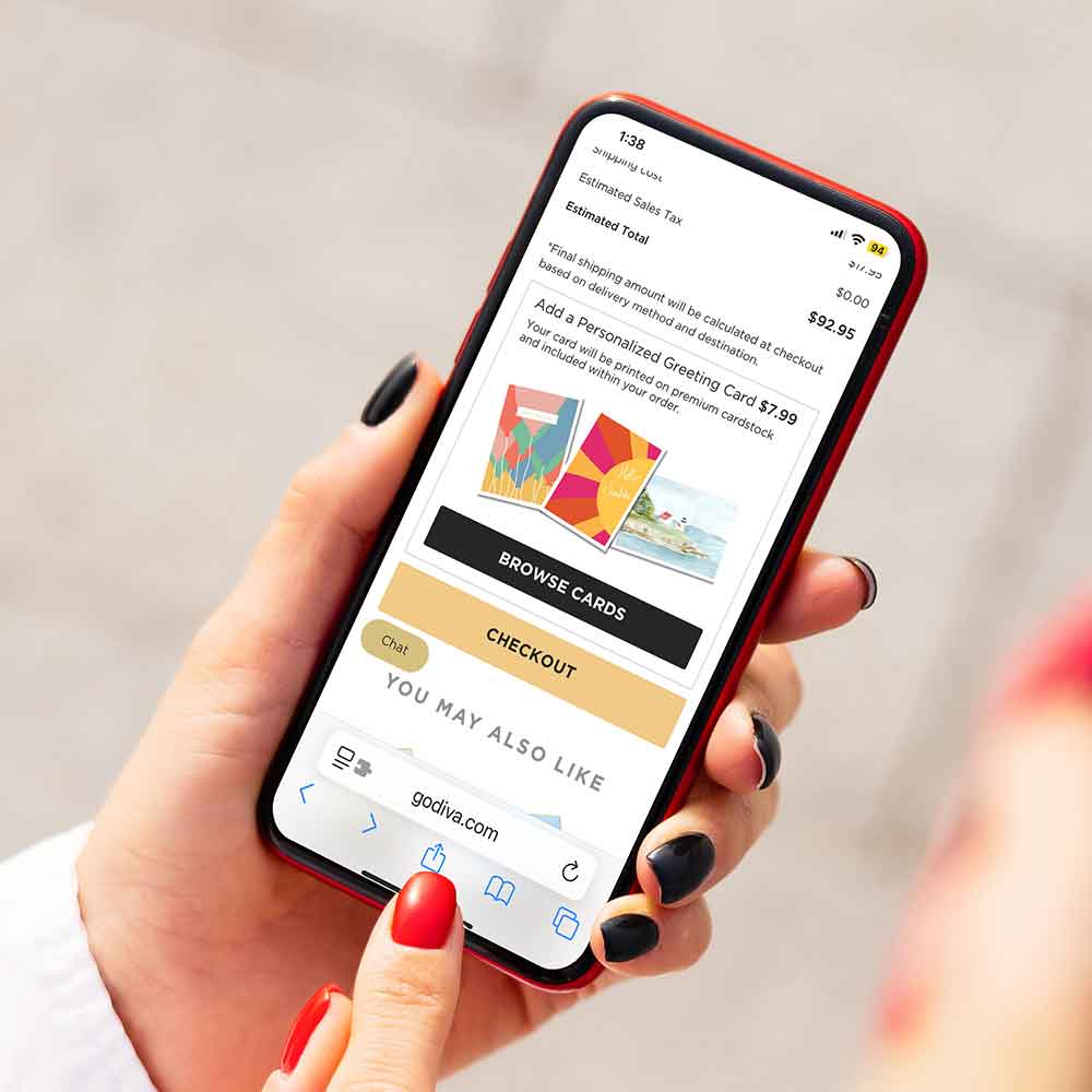 Person holding a smartphone with a shopping app open on a light gray background