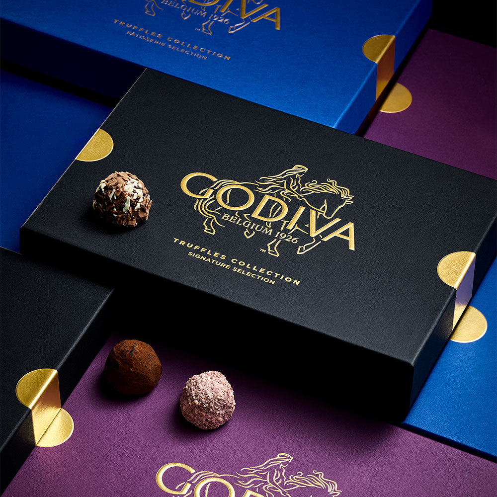 Godiva chocolate truffles with packaging on a purple surface